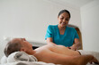© ADDICTIVE STOCK - Female therapist providing massage to male client at home