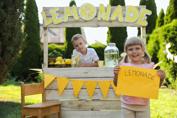 Sticker - Little girl holding price tag near lemonade stand in park