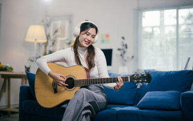 young woman playing acoustic guitar in her cozy living room, fully immersed in music, showcasing tal