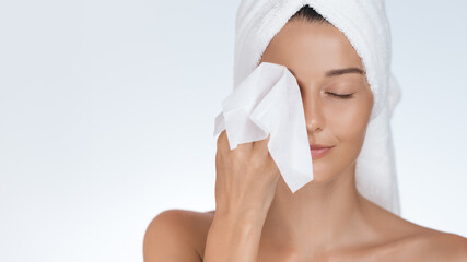 woman cleansing face with makeup remover wipe in skincare routine