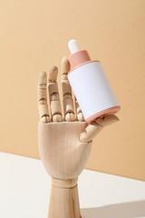 Wall Mural - A cosmetic bottle in a mannequin's wooden hand