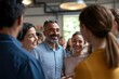 © Ganesha - A diverse group of businesspeople standing in a circle, smiling and hugging each other, celebrating success at work. Conceptual photo about successful team building, with a male manager talking to fem