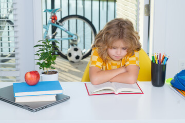 Fototapete - School kid reading book. School child studying at home. Kid studying on lesson doing homework. Elementary school and home schooling. Distance education concept.