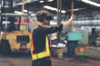 © amorn - Male factory mechanic using virtual reality headset. Male engineer working with virtual reality headset and holding laptop computer in industry factory while control machinery