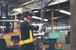 © amorn - Male factory mechanic using virtual reality headset. Male engineer working with virtual reality headset and holding laptop computer in industry factory while control machinery