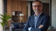 © Johannes - smiling mid aged business man executive standing in office, mature confident professional manager, confident businessman investor looking at camera, portrait