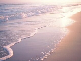 Canvas Print - At sunrise, soft waves lap the shore of a peaceful beach, creating gentle shadows on the wet sand while the pastel-colored sky reflects warm light