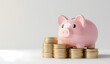 © ZenArt - Pink piggy bank and gold coins on a white background