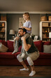 © La Famiglia - Teaching fitness. Father and his little daughter are at home together doing workout and having fun