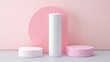 © Anna - In a serene setting, a white cylindrical shape stands between two circular forms in soft pink and white tones, set against a pale pink backdrop, highlighting minimalist design elements