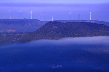 Landscape of windmills in the mountain with fog.