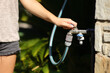 © Antonioguillem - Woman hand opening hose faucet in a garden
