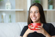 © Antonioguillem - Happy woman smiling drinking coffee at home looking at side