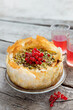 © Silviya - Whole baklava cheesecake with fresh red currant and drinks, baked filo pastry dessert on wooden table