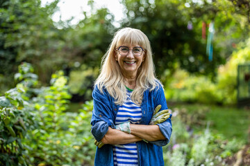 Portrait of smiling senior woman standing in her garden
