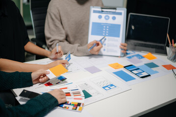 Wall Mural - close up view of ui developer team brainstorming on their project with laptop, smartphone and digita