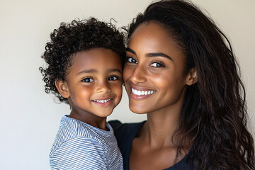 Wall Mural - Mixed racial young mother and cute daughter smiling and interacting in front of a plain background, dressed in simple  clothes, captured in a family photo portrait shoot showcasing their joyful bond