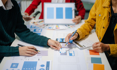 Wall Mural - close up view of ui developer team brainstorming on their project with laptop, smartphone and digita
