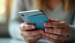 © Ali Hamza Tullah - Close up of woman hold bank credit card shopping online using mobile phone, buying goods or ordering online, entering bank accounts and details in online banking offer.