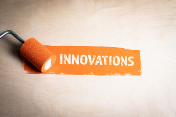 Wall Mural - Innovations. Orange paint and paint roller on wood texture background