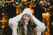 © polinaloves - Young beautiful woman enjoying Christmas decorations on city street.