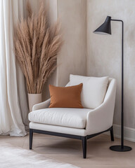 Cozy living room corner with a white armchair, brown pillow, and stylish floor lamp against a backdrop of dried plants