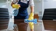© hobonski - Office Cleaning Staff Sanitizing Conference Table. A dedicated cleaning professional in a blue uniform and yellow gloves meticulously cleans a glass table in a contemporary office setting.