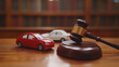 © ceng - A gavel rests on a wooden block, with two toy cars in the foreground, symbolizing legal disputes related to vehicle accidents.