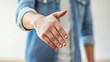 © Papugrat - a person extending their hand for a handshake in a professional setting