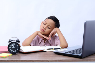 Thoughtful Asian schoolboy studying in the classroom. Isolated on white background