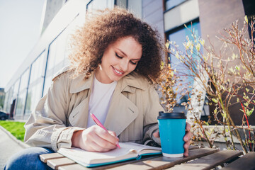 Wall Mural - Photo of lovely cute girl enjoying sunny weather outdoors sitting on cafe terrace drinking cappuccino