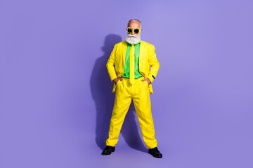 Wall Mural - Full body portrait of funny extravagant aged man posing yellow suit isolated on purple color background