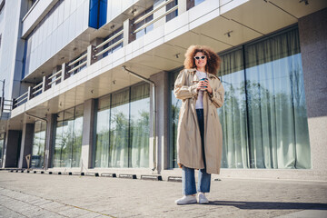 Wall Mural - Photo of good mood cute girl dressed stylish beige clothes walking big city center spring sunny weather outdoors