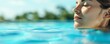 © Thanaphon - Relaxed woman floating in a tranquil pool on a sunny day, enjoying serenity and peace with the clear blue sky in the background.