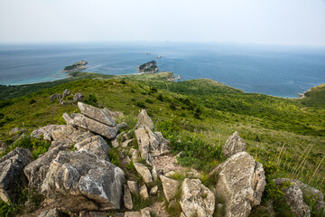 A breathtaking view of the vast ocean from a rocky hillside