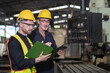 © amorn - Two male engineer checking, repair, maintenance CNC machine in factory. Group of male technician working with CNC machine during manufacturing process