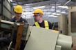© amorn - Two male engineer checking, repair, maintenance CNC machine in factory. Group of male technician working with CNC machine during manufacturing process