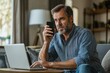 © Joaquin Corbalan - A concerned man receives a scam call while working on his laptop in a cozy living room during a quiet afternoon