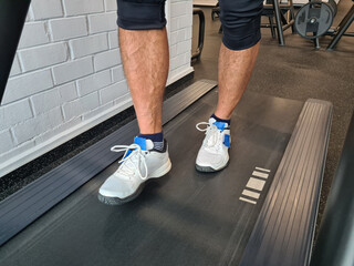 Individual walking on a treadmill in a fitness center during a workout session in the afternoon