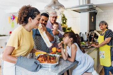 Latin family cooking together for Christmas dinner at home in Mexico Latin America, hispanic mother, grandparents and daughter preparing turkey meat in holidays