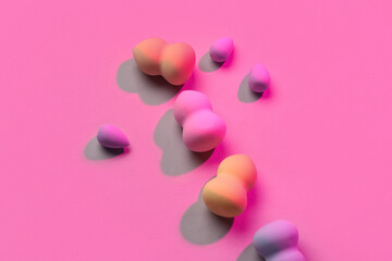 Wall Mural - Different makeup sponges on pink background