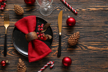 Christmas table setting with red napkin and berries on wooden table