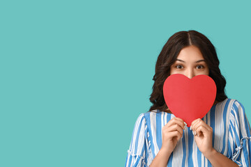 Poster - Beautiful young Asian woman with red paper heart on blue background. Valentine's Day celebration