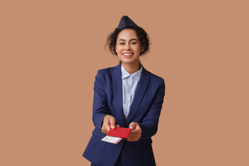 Canvas Print - Beautiful African-American stewardess with passport and ticket on beige background