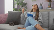 © Krakenimages.com - A joyful young woman with a tablet in a cozy living room alongside her resting chihuahua