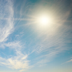 Wall Mural - bright sun on blue sky and cirrus clouds.