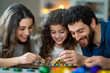 © EmmaStock - A family gathered around the table, playing dreidel, with piles of Hanukkah gelt and colorful decorations in the background.