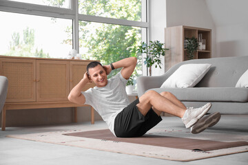 Poster - Sporty young man training on mat at home