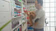 © Krakenimages.com - Hispanic man holding dog in a pharmacy checking medicine