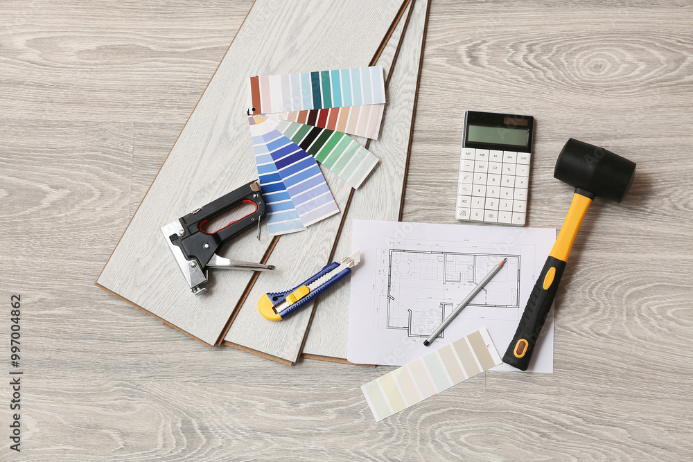 Tools, calculator, house project, color palettes and laminate boards on floor